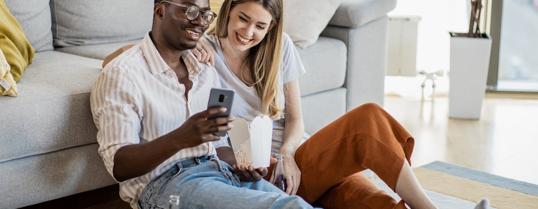 lifestyle image of a couple interacting over a video call in a bright living area